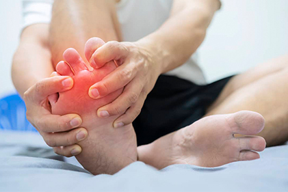 Man on bed with painful swollen foot